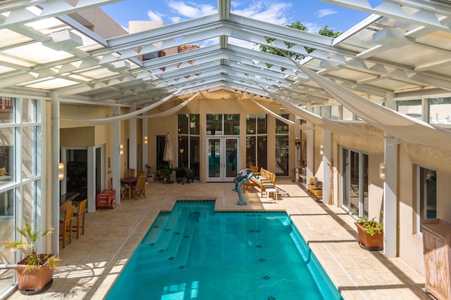 rear view of property with a patio, french doors, and an outdoor pool