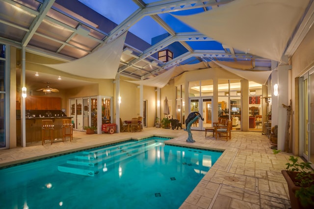 pool with glass enclosure, french doors, and a patio area