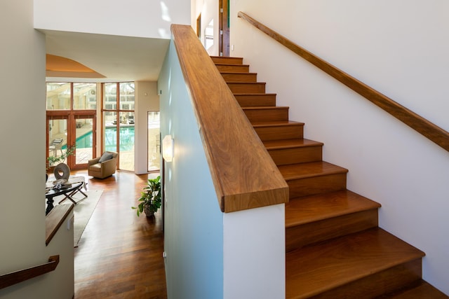 stairway featuring expansive windows and wood finished floors