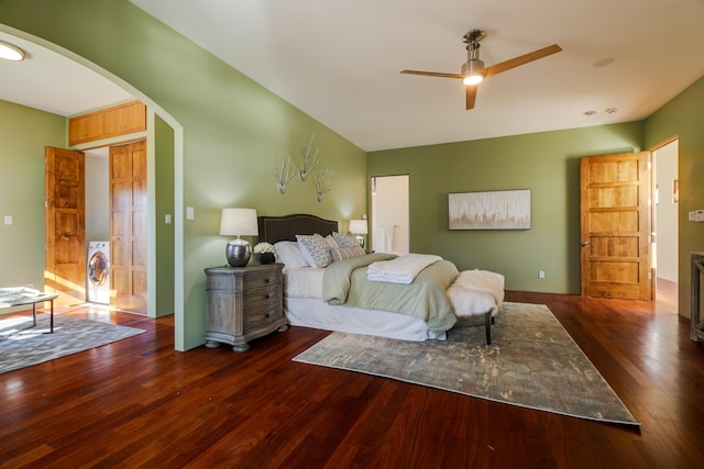 bedroom with arched walkways, washer / clothes dryer, and wood finished floors