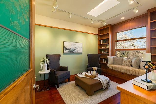 interior space with dark wood-type flooring, a skylight, and rail lighting