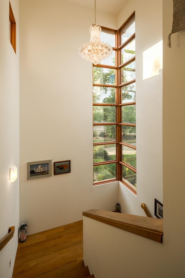 staircase featuring a chandelier and wood finished floors