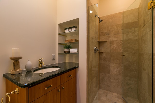 bathroom featuring a tile shower and vanity