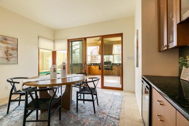 interior space featuring wine cooler, light tile patterned floors, decorative backsplash, a sink, and wet bar