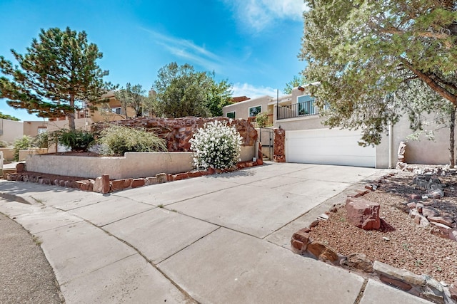 view of front of house featuring a garage, concrete driveway, and stucco siding