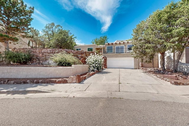 view of front of property featuring a garage, concrete driveway, and stucco siding