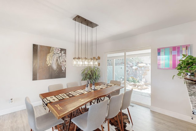 dining area with baseboards and wood finished floors