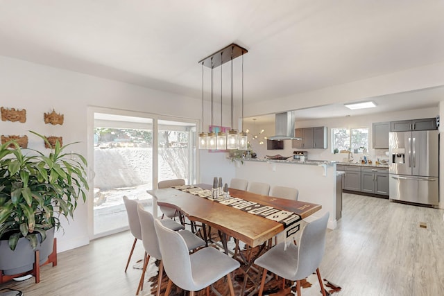 dining space featuring light wood-style flooring and baseboards