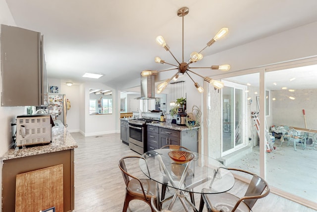 dining area with light wood-style floors, baseboards, and a notable chandelier