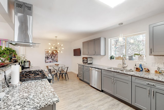 kitchen featuring dishwasher, island exhaust hood, gray cabinetry, light wood-type flooring, and a sink