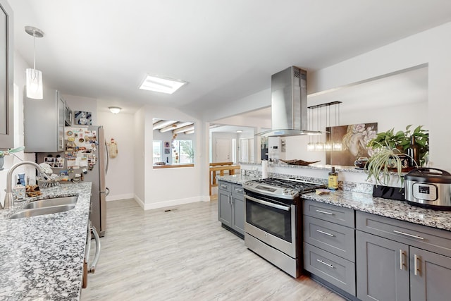 kitchen featuring light stone counters, gray cabinetry, island range hood, stainless steel appliances, and a sink