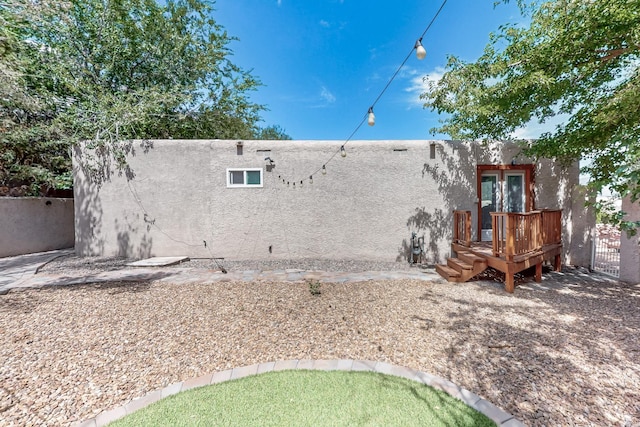 back of property with fence and stucco siding