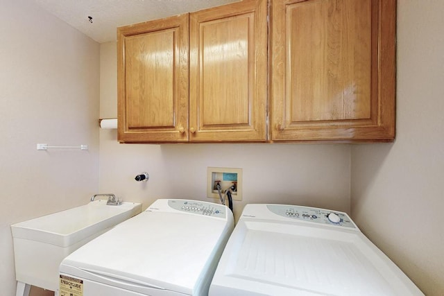 laundry area featuring a sink, cabinet space, and independent washer and dryer