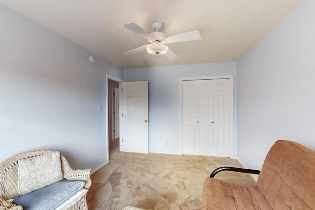 sitting room with baseboards, ceiling fan, and carpet flooring