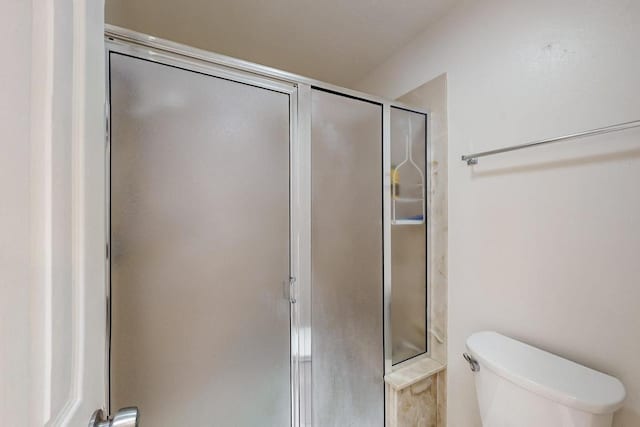 full bathroom with a stall shower and toilet