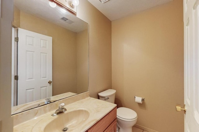 bathroom with visible vents, toilet, vanity, and baseboards