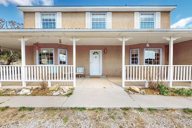 view of front of house featuring stucco siding and covered porch