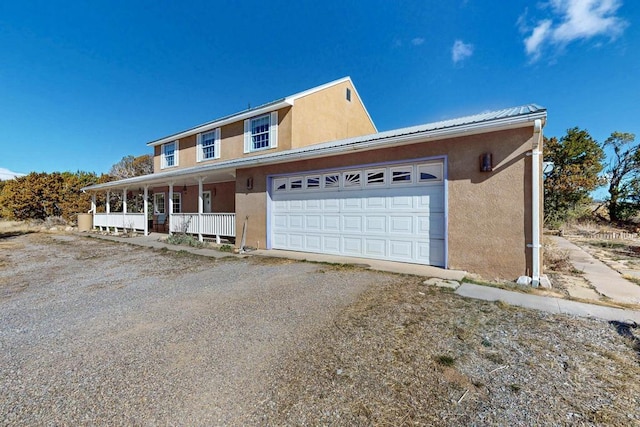 view of front of property featuring a porch, an attached garage, driveway, and stucco siding