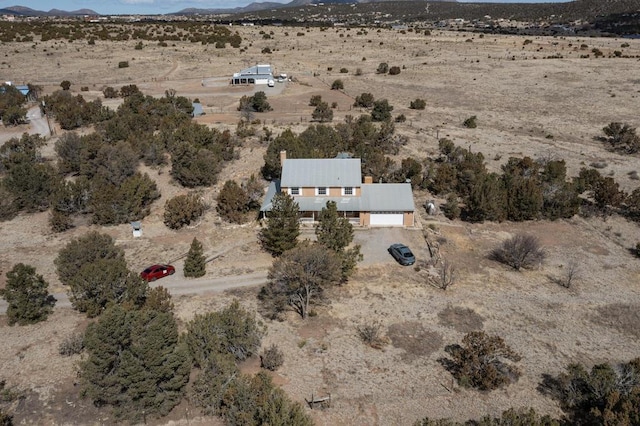 birds eye view of property featuring a mountain view and view of desert