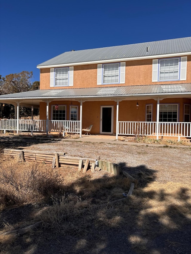 view of front of house featuring stucco siding and a porch