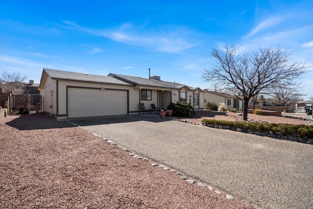 view of front of home featuring aphalt driveway, fence, and an attached garage