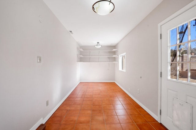 interior space featuring baseboards, visible vents, and tile patterned floors