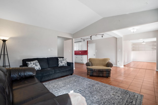 living room featuring tile patterned flooring, baseboards, vaulted ceiling, and track lighting