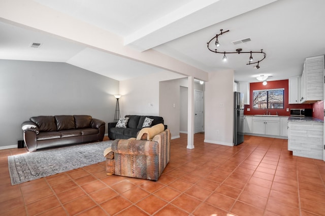 living area featuring lofted ceiling, light tile patterned floors, baseboards, and visible vents