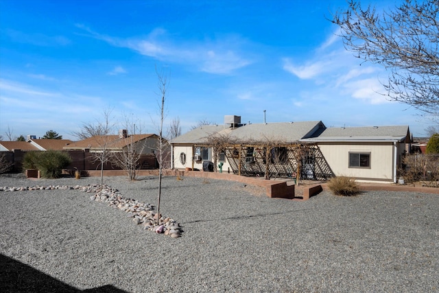 back of property featuring fence and a patio