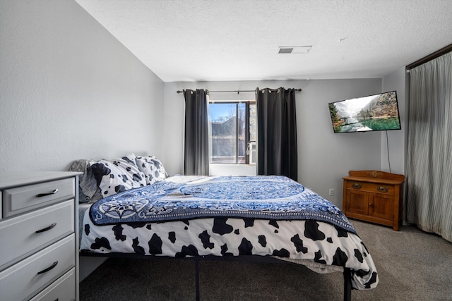 bedroom with carpet floors, visible vents, and a textured ceiling