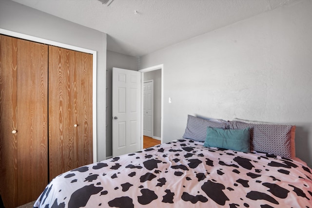 bedroom with a textured ceiling and a closet