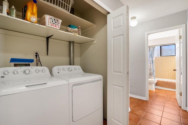 laundry area with light tile patterned floors, laundry area, separate washer and dryer, and baseboards