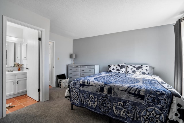 bedroom featuring light carpet, a textured ceiling, light tile patterned flooring, and connected bathroom