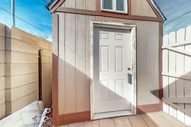 entrance to property with board and batten siding and fence