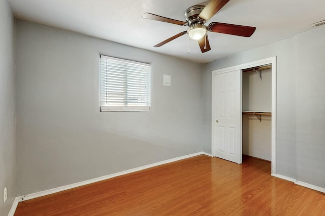 unfurnished bedroom with a ceiling fan, a closet, baseboards, and wood finished floors