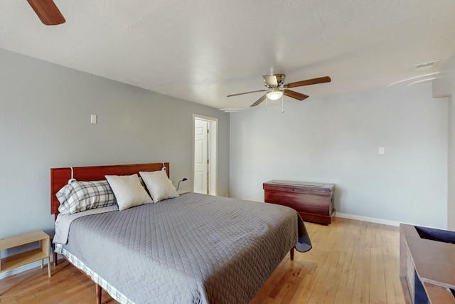 bedroom featuring a ceiling fan, light wood-style flooring, and baseboards