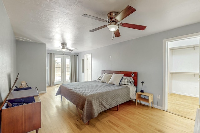 bedroom with a ceiling fan, access to outside, french doors, and light wood-style flooring