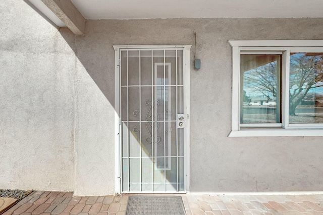 entrance to property featuring stucco siding