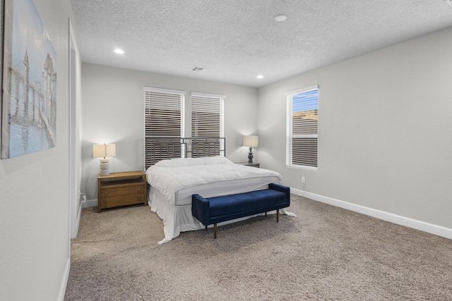 bedroom featuring visible vents, a textured ceiling, recessed lighting, carpet, and baseboards