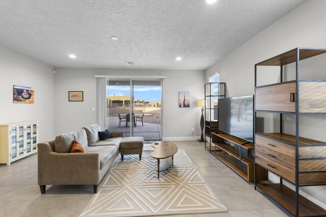 living area with light tile patterned floors, recessed lighting, a textured ceiling, and baseboards