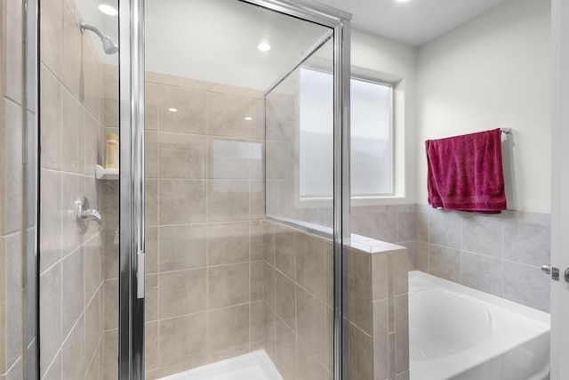 bathroom with a bath, a stall shower, and a wealth of natural light