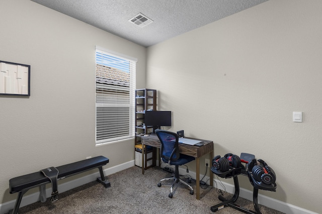 carpeted home office featuring visible vents, baseboards, and a textured ceiling