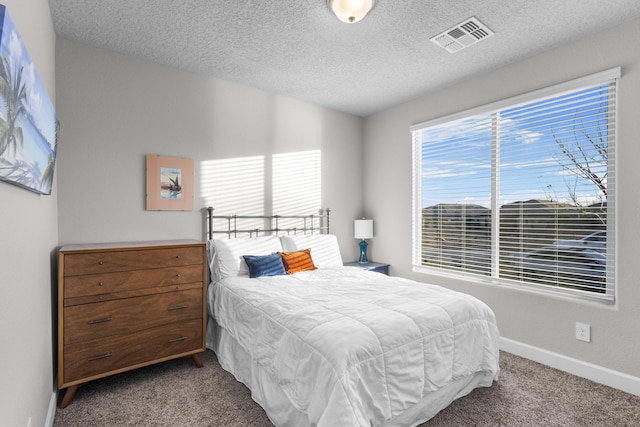 carpeted bedroom with visible vents, baseboards, a textured ceiling, and vaulted ceiling