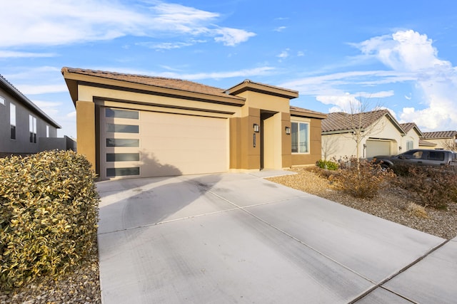 view of front facade with stucco siding, an attached garage, and concrete driveway