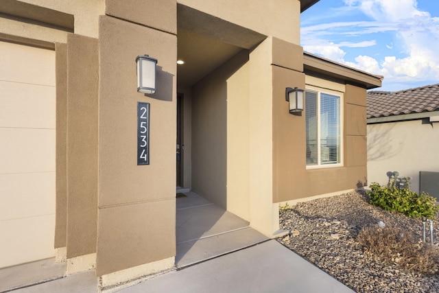 doorway to property featuring stucco siding