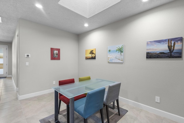 dining area with recessed lighting, baseboards, a textured ceiling, and a skylight