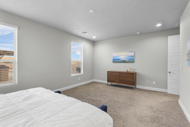 bedroom featuring visible vents, baseboards, carpet floors, recessed lighting, and a textured ceiling