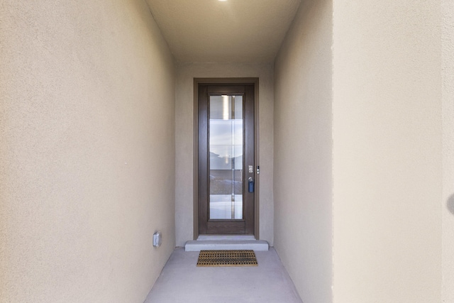 entrance to property featuring stucco siding