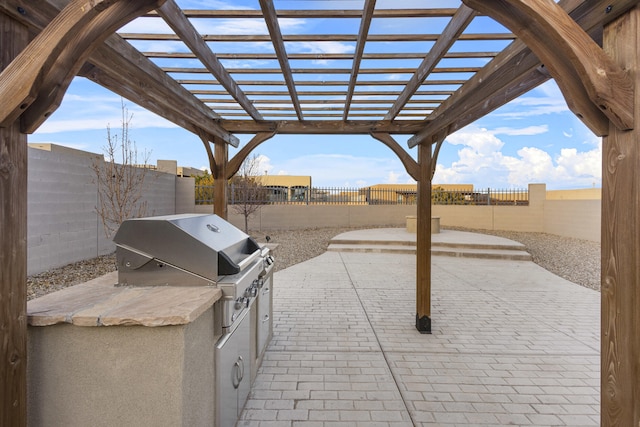 view of patio / terrace featuring exterior kitchen, a fenced backyard, a pergola, and grilling area