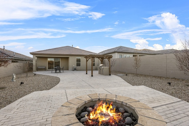 rear view of house featuring an outdoor fire pit, a fenced backyard, a pergola, stucco siding, and a patio area